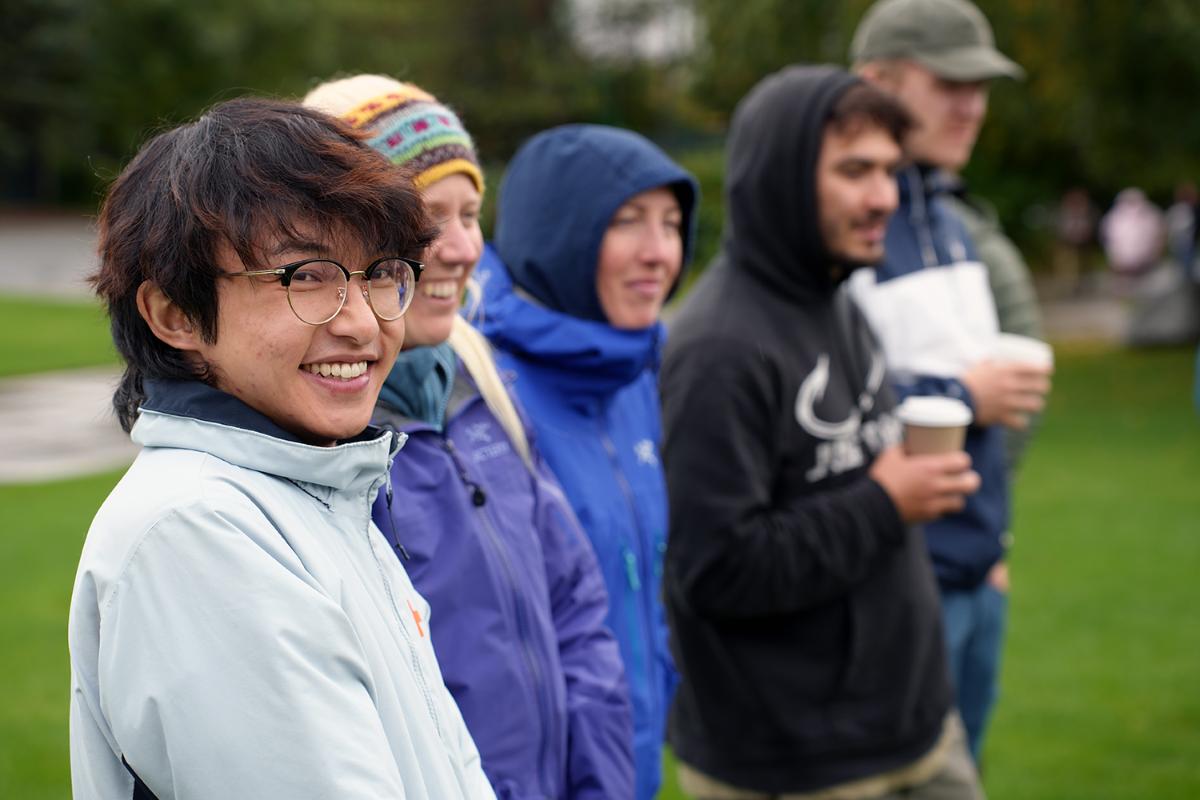 Personer står ved siden av hverandre utendørs.